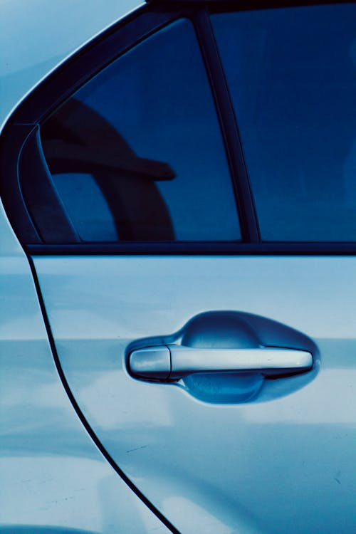 Close-up of a modern car door with blue ceramic window tint.