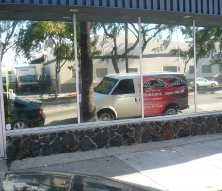  Front-facing glass windows of a commercial building with visible window tint