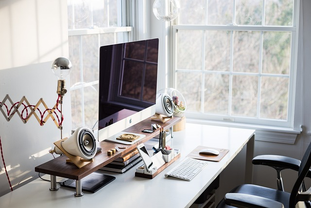 This photo shows a window, computer, chair and a table setup