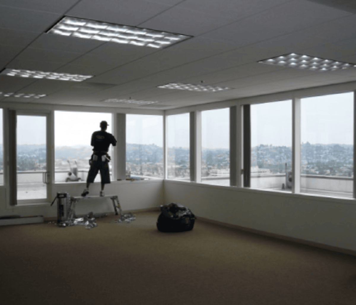 Professional from Luxury Glass Tinting applying window film to a Los Angeles office
