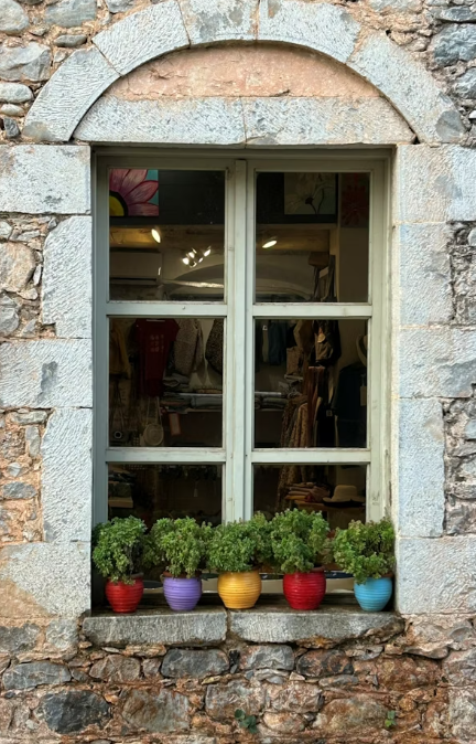 This image shows a window with colorful flowerpots.