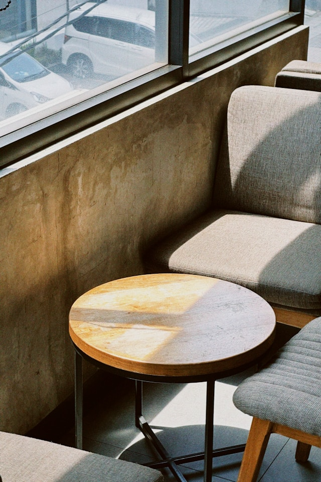This photo shows a wooden table and chair faded from direct sunlight