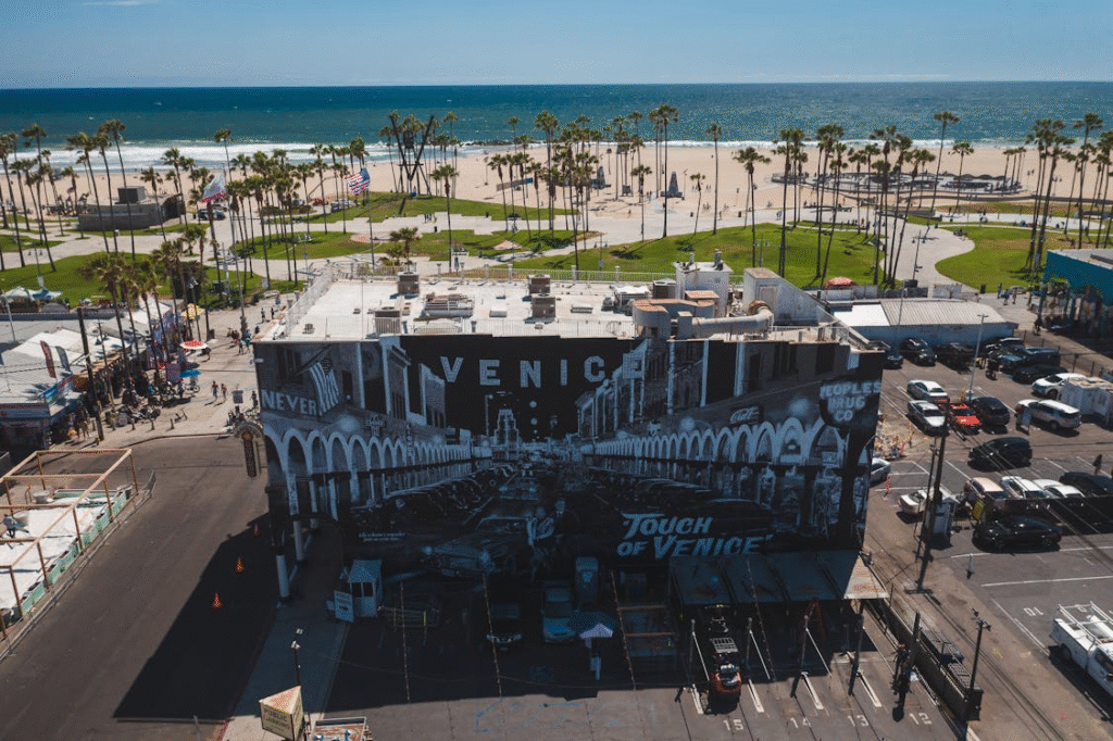 Aerial view of Venice Beach with nearby retail storefronts and commercial buildings.