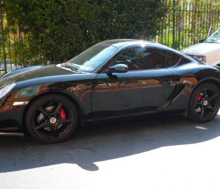 A car parked in sunlight with glossy paint preserved by paint protection film.