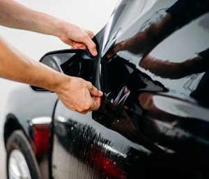 Professional technician carefully applying ceramic window tint in Los Angeles.