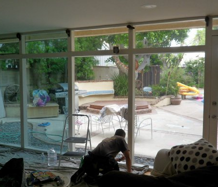 Professional installer applying sun-blocking window film to a residential window in Los Angeles