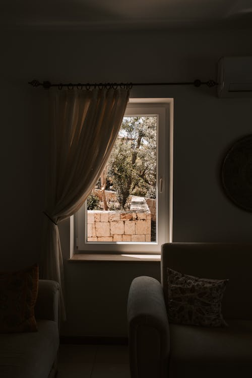 A comfortablereading nook next to a window treated with solar film, showing reduced glare and protected interiors.