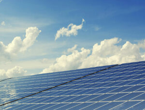 Reducing carbon footprint and energy costs Solar panels under a bright blue sky with scattered clouds