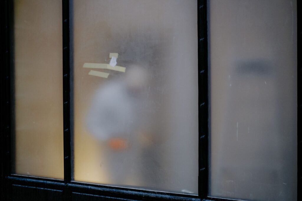 Frosted privacy window film obscuring a person behind glass panels