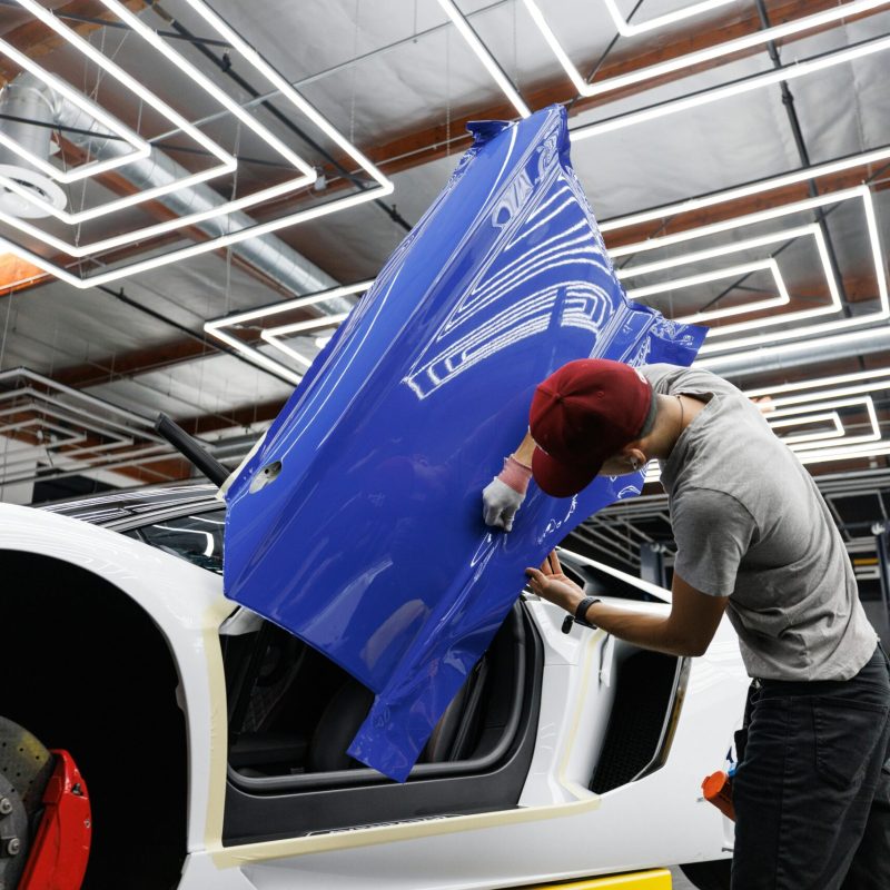 technician applying automotive window tinting film on white car scaled